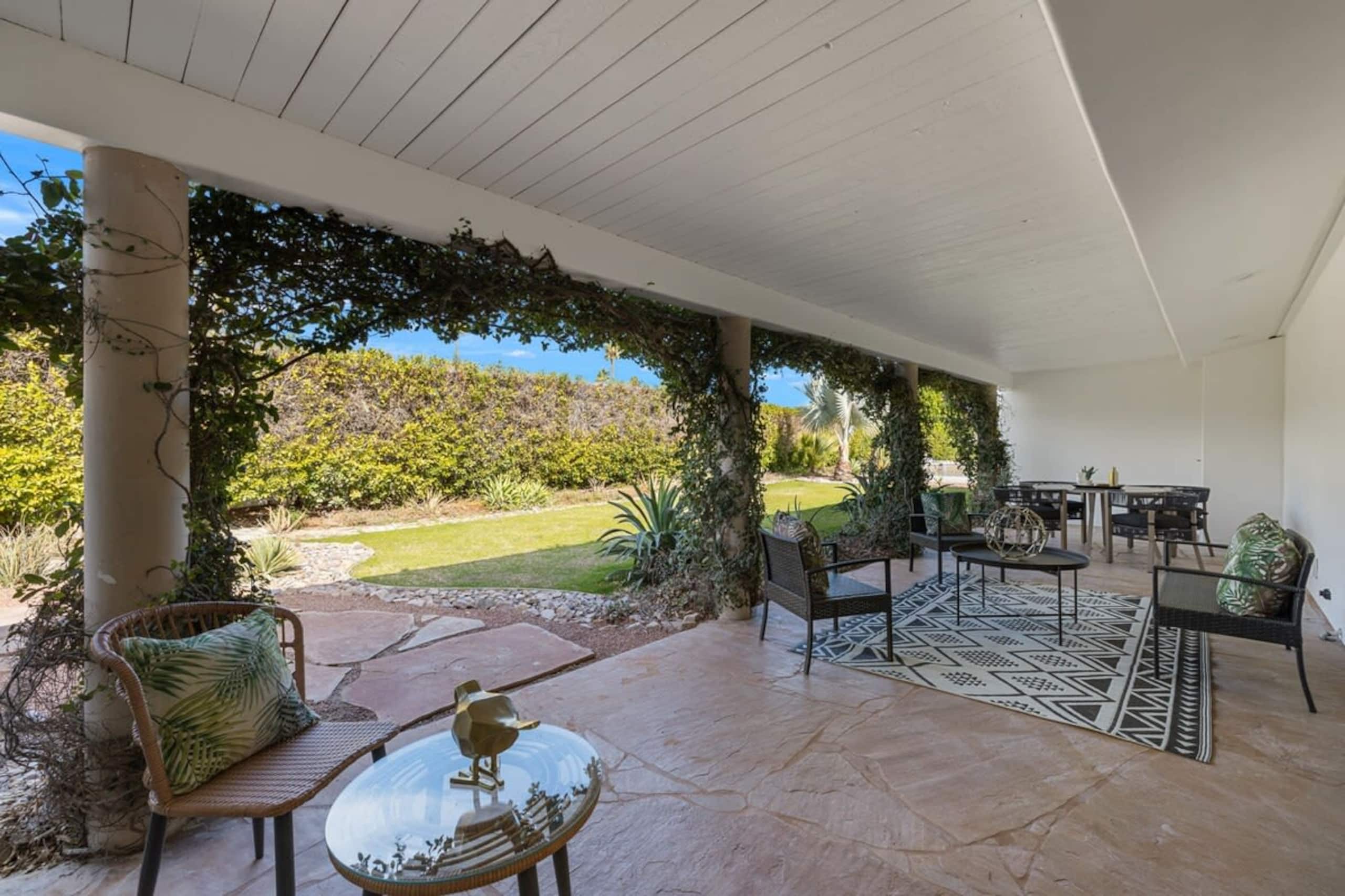 Covered veranda with ivy-wrapped columns overlooking the lawn